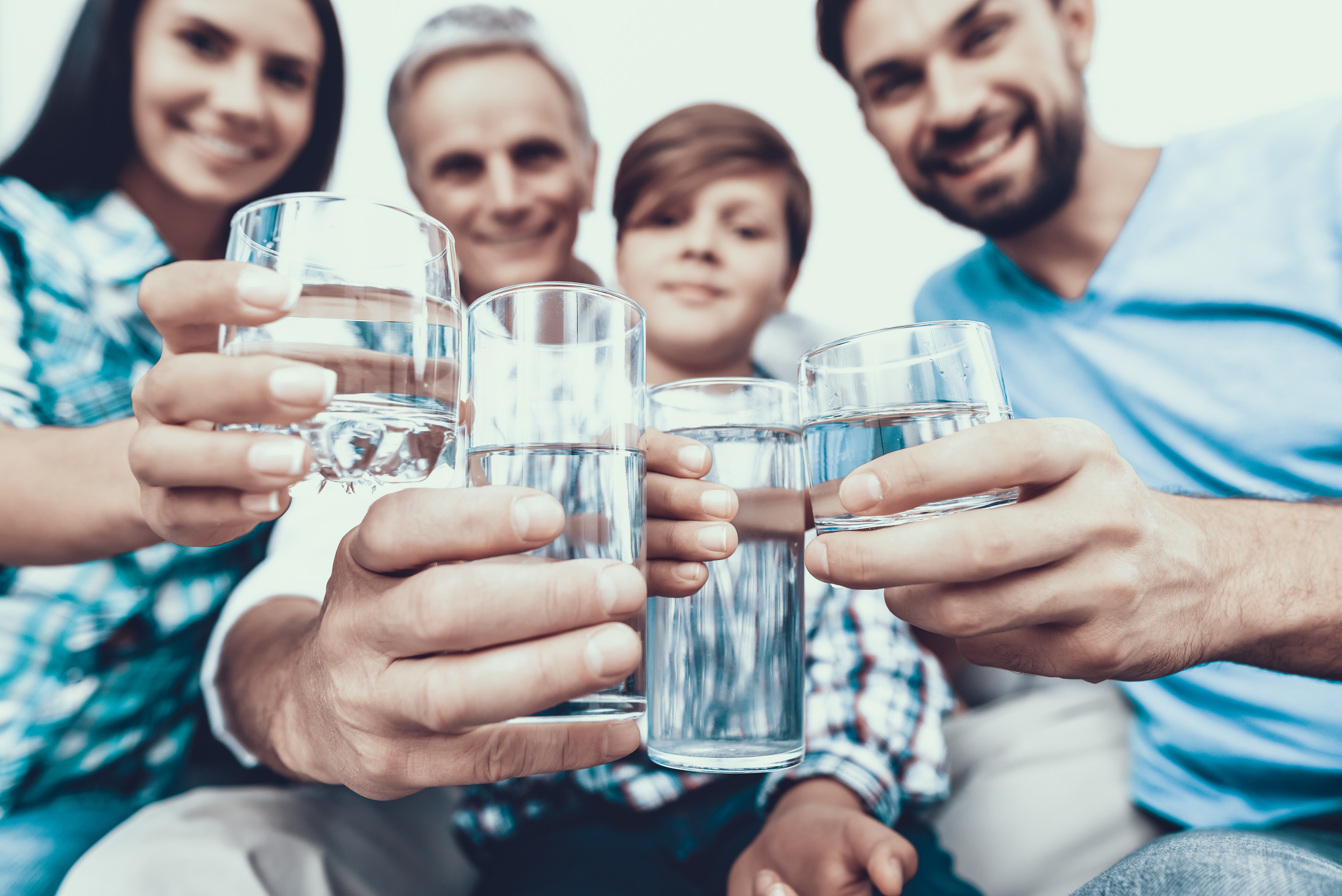 Happy family holding glasses of pure water
