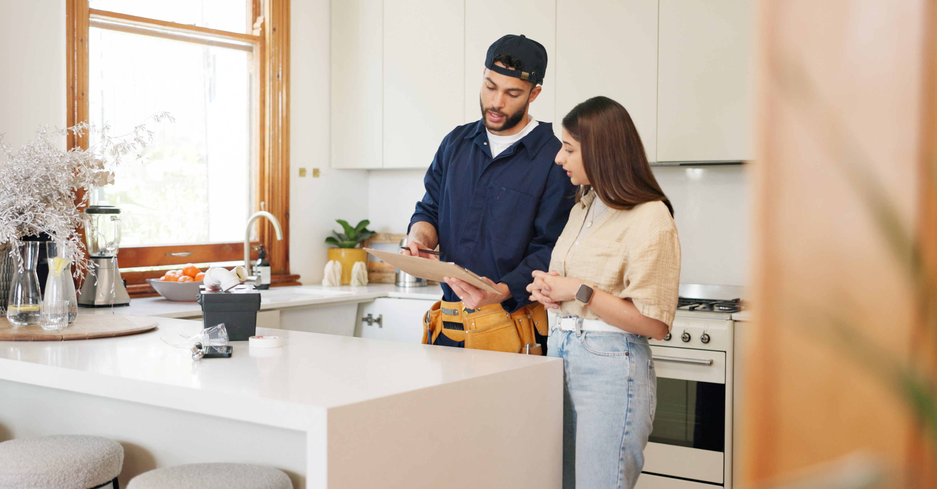 Technician reviewing water test results with homeowner in kitchen
