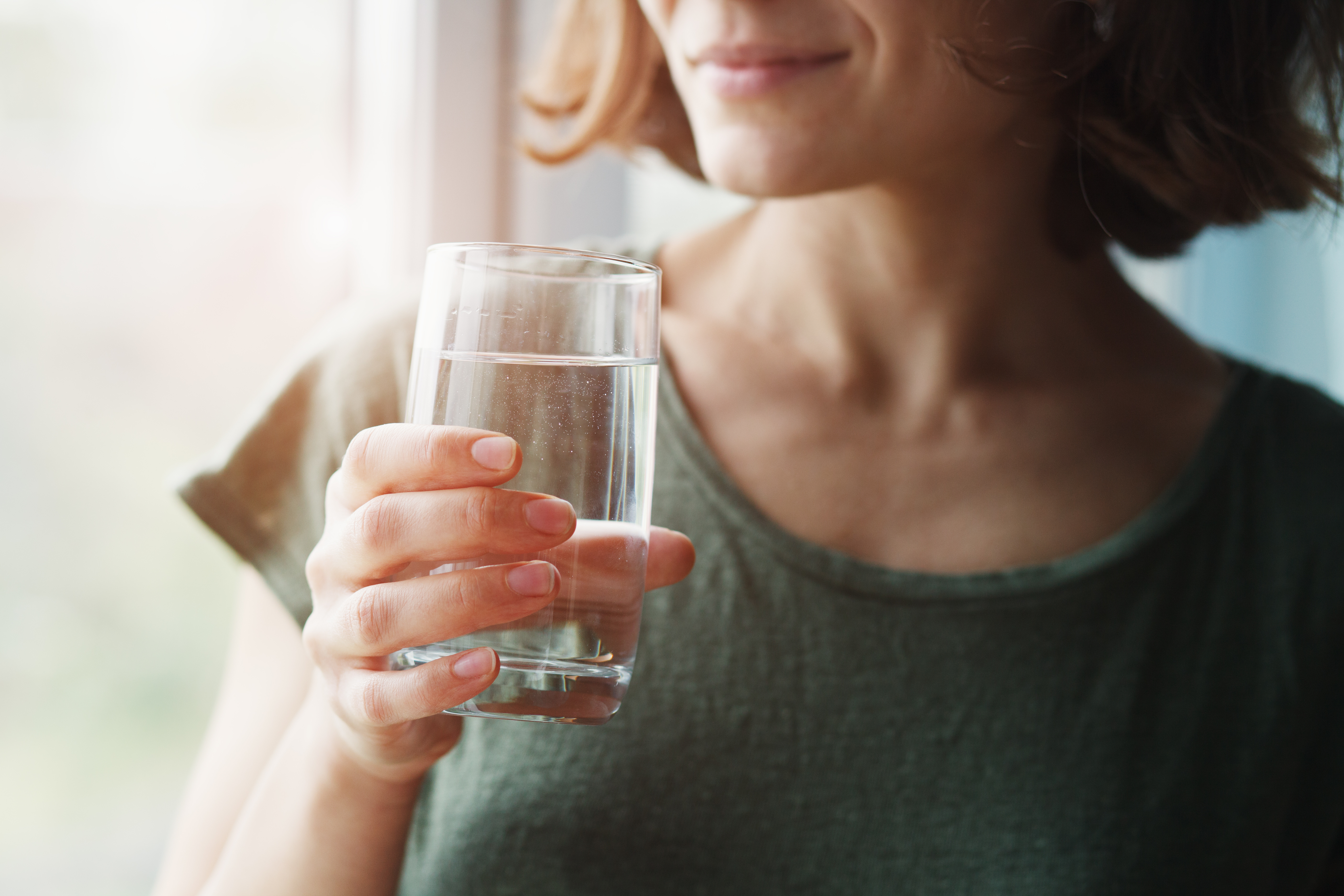 Woman holding a glass of clean purified water